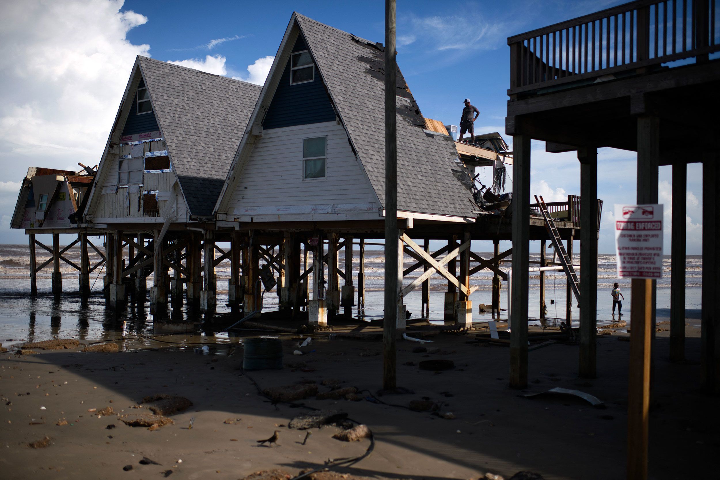 A man surveys a damaged home in Surfside Beach, Texas, on Monday, July 8.