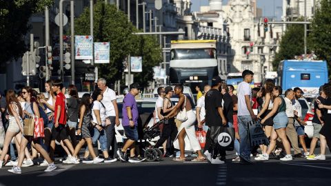 Personas cruzan la Gran Vía en el centro de Madrid, el 3 de julio de 2024