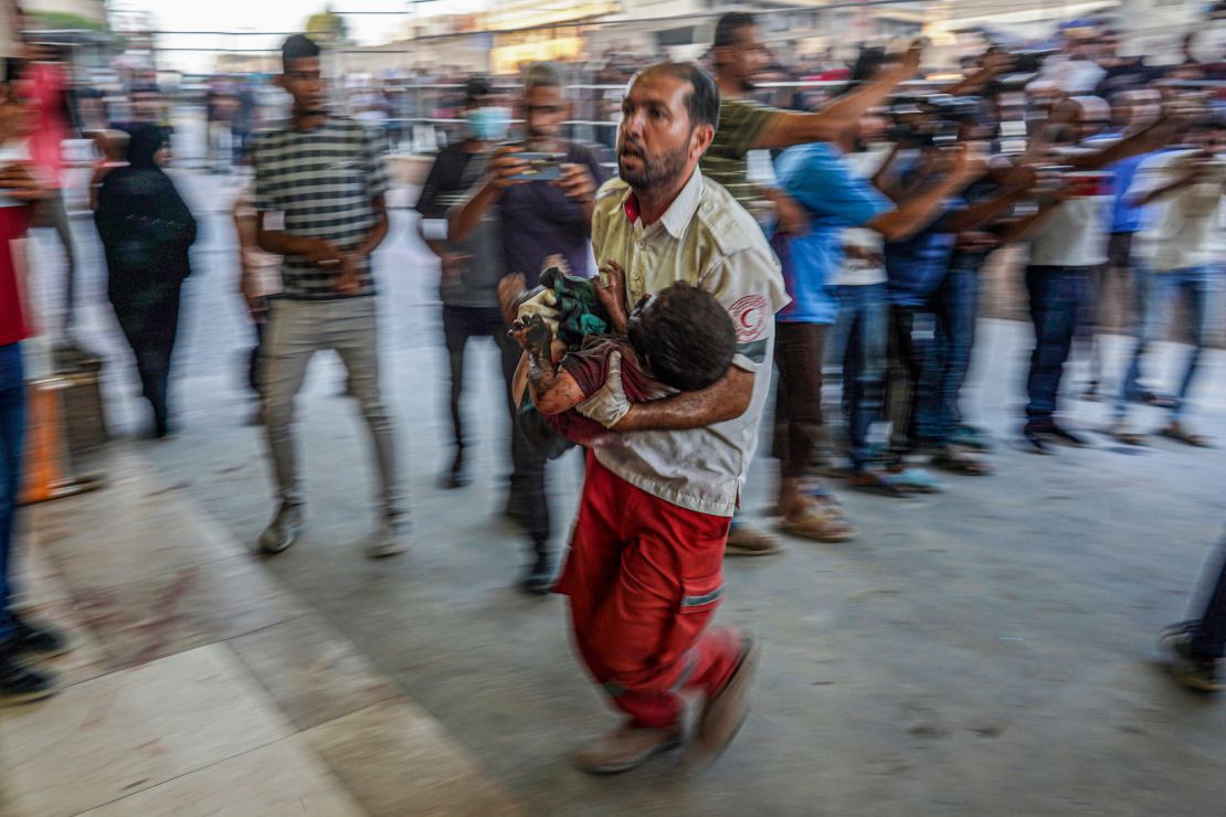 A paramedic carries a wounded child to the emergency ward in Khan Younis, in the southern Gaza Strip, on July 9, 2024.