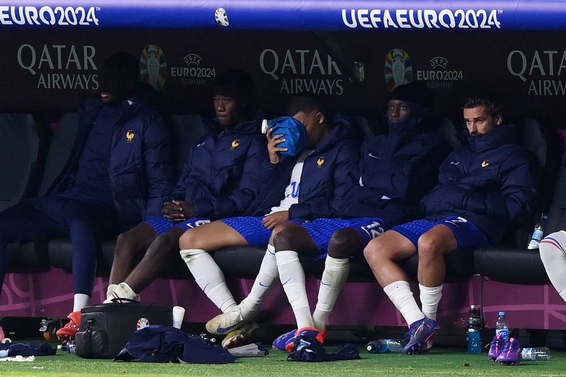 Mbappé holds an ice pack on his nose as he looks on from the bench after being substituted in extra-time during France's game against Portugal.