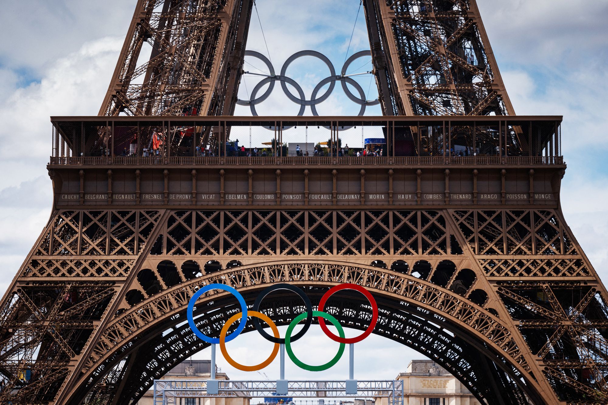 This photograph shows the Olympic Rings displayed at the construction site of the Eiffel Tower Stadium for the upcoming Paris 2024 Olympics and Paralympic Games which will host the Beach Volleyball and men's Blind Football competitions, at the Champ-De-Mars in Paris on July 10, 2024. The Champ de Mars and the Trocadero, located on either side of the Eiffel Tower, will host several events of the Paris Olympic and Paralympic Games, on July 10, 2024. (Photo by Dimitar DILKOFF / AFP) (Photo by DIMITAR DILKOFF/AFP via Getty Images)