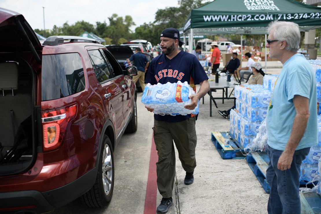 A man loads a case of water into a car at a water and food distribution center in Houston, Texas on July 11, 2024. Millions of people in Texas are still grappling with power outages and facing the looming dangers of intense heat and humidity following Hurricane Beryl. (Photo by Mark Felix / AFP) (Photo by MARK FELIX/AFP /AFP via Getty Images)