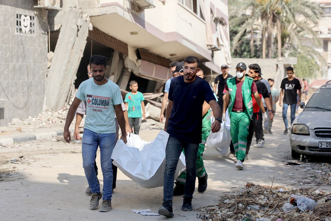 Palestinians recover bodies found under the rubble in Al-Sina'a Street, on July 12, following the withdrawal of Israeli forces in central and northern Gaza.