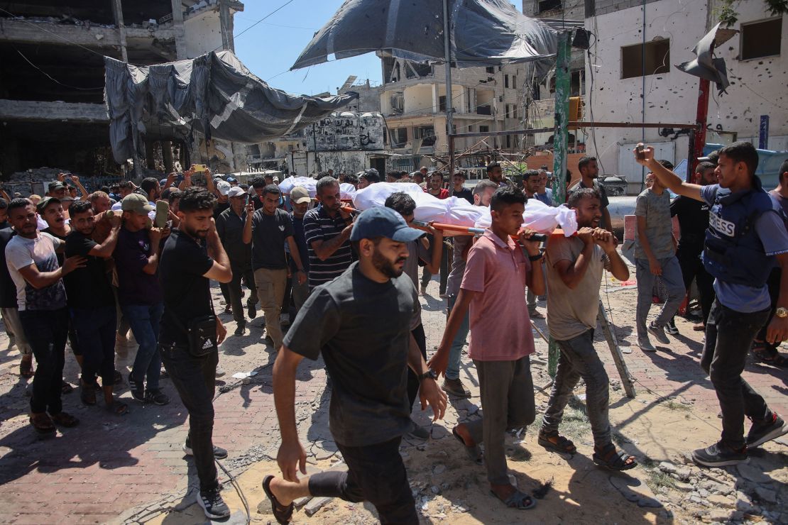 Palestinian mourners carry the bodies of relatives killed during an Israeli strike which hit a makeshift prayer hall at Al Shati refugee camp west of Gaza City on July 13, 2024.