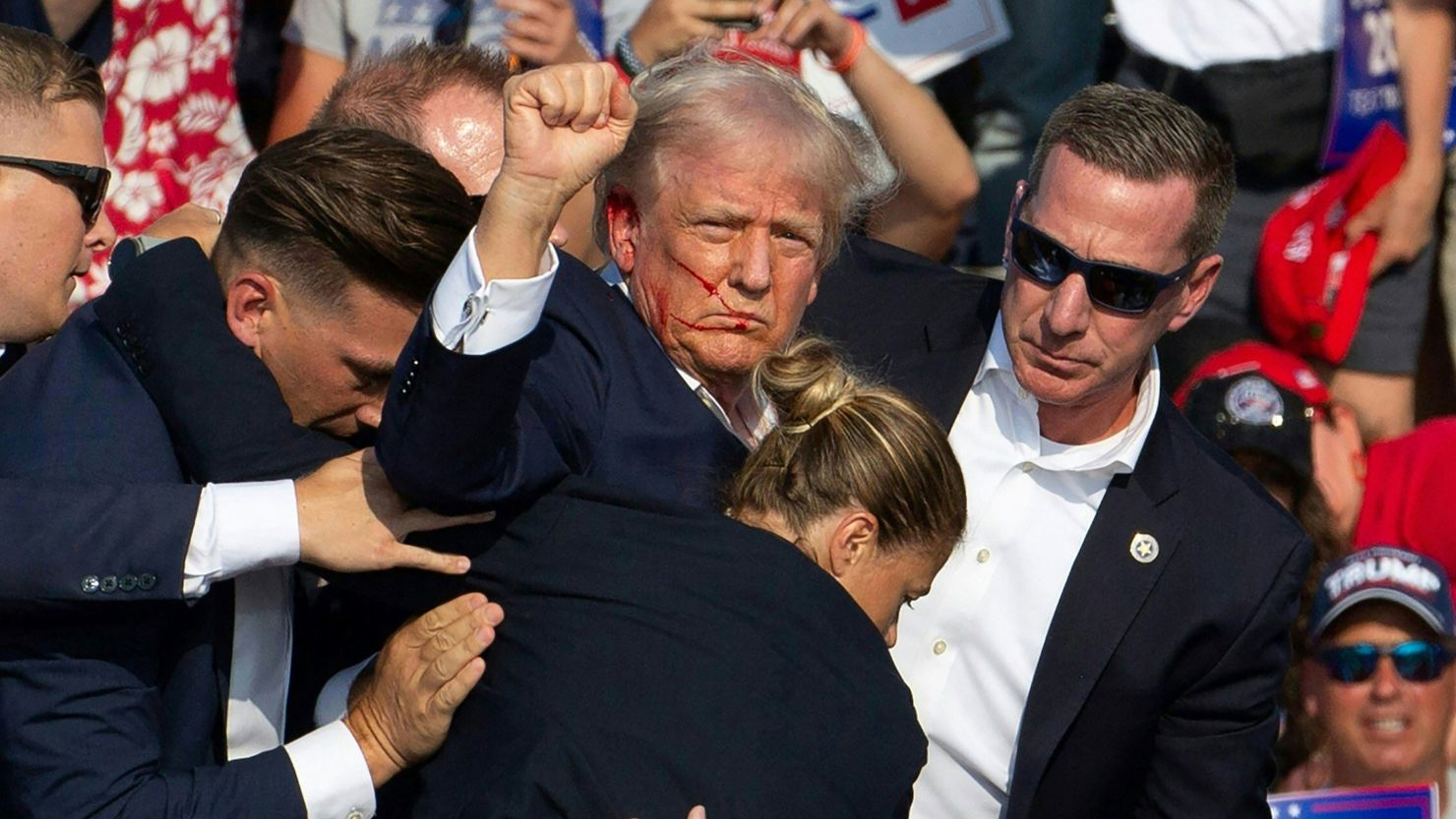 Donald Trump is surrounded by secret service agents as he is taken off the stage at a campaign event at Butler Farm Show Inc. in Butler, Pennsylvania, July 13, 2024.