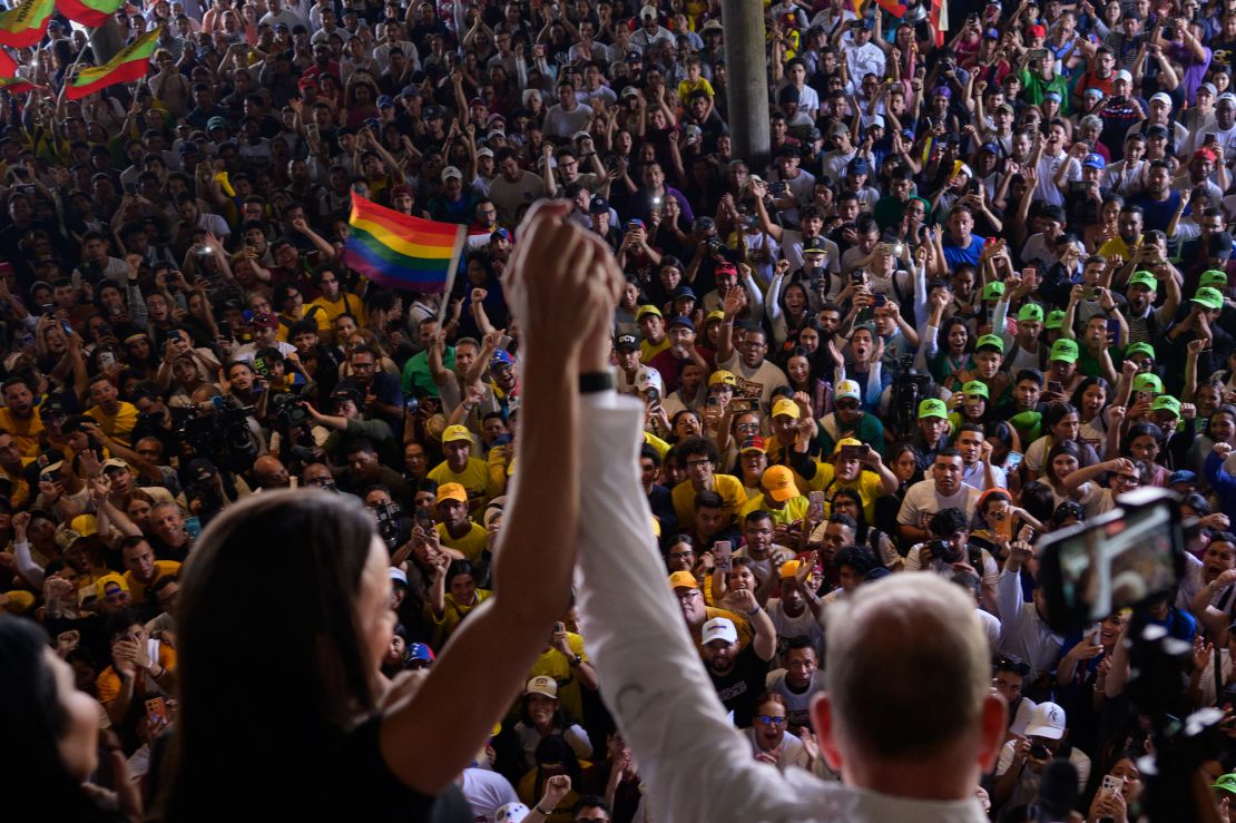 Venezuelan presidential candidate Edmundo Gonzalez and opposition leader Maria Corina Machado greet students during a campaign rally at the Central University of Venezuela in Caracas on July 14, 2024.