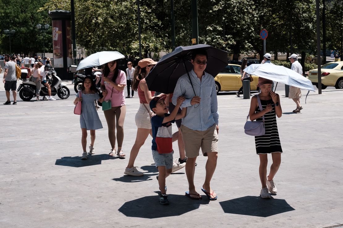 Tourists shielding from the heat in Athens, Greece, on July 16, 2024.