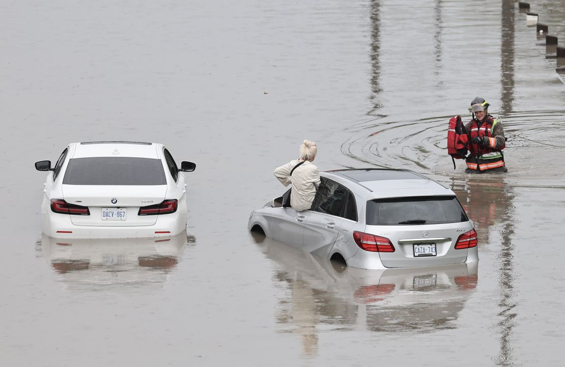 TORONTO, ON - July 16 Kathy Stiliadis awaits a firefighter who helped her out of her car. Heavy rains hammered Toronto on Tuesday morning. A number of motorists were stranded on the DVP as it completely flooded at Dundas street. Several people were rescued from their cars by Toronto fire. July 16 2024 Richard Lautens/Toronto Star (Richard Lautens/Toronto Star via Getty Images)