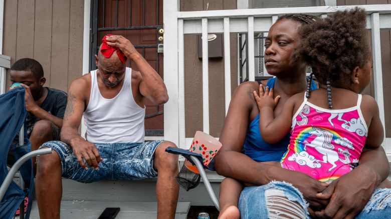 The Coleman family sit together on their front porch as they get some air on July 12, 2024 in Houston, Texas.
