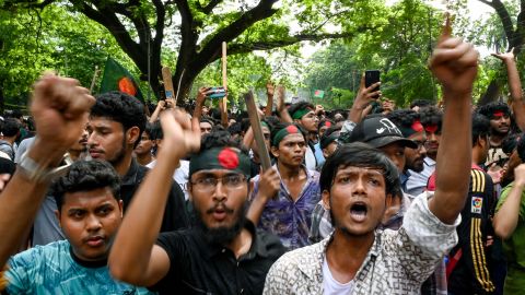Students wearing headbands with Bangladesh's national flag shout slogans during a protest against quotas in government jobs at Dhaka University in the capital on July 17, 2024. Bangladeshi students on July 17, mourned classmates killed in protests over civil service hiring rules, a day after the government ordered the indefinite closure of schools nationwide to restore order. (Photo by Munir UZ ZAMAN / AFP) (Photo by MUNIR UZ ZAMAN/AFP via Getty Images)