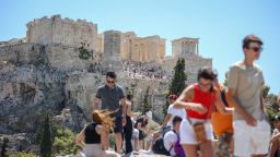 Tourists leave the Acropolis hill in Athens, on July 17, 2024. The Greek Ministry of Culture announced a precautionary measure to ensure the safety of visitors during the heatwave, restricting access to the Acropolis site between 12pm and 5pm. (Photo by Aris Oikonomou / AFP) (Photo by ARIS OIKONOMOU/AFP via Getty Images)