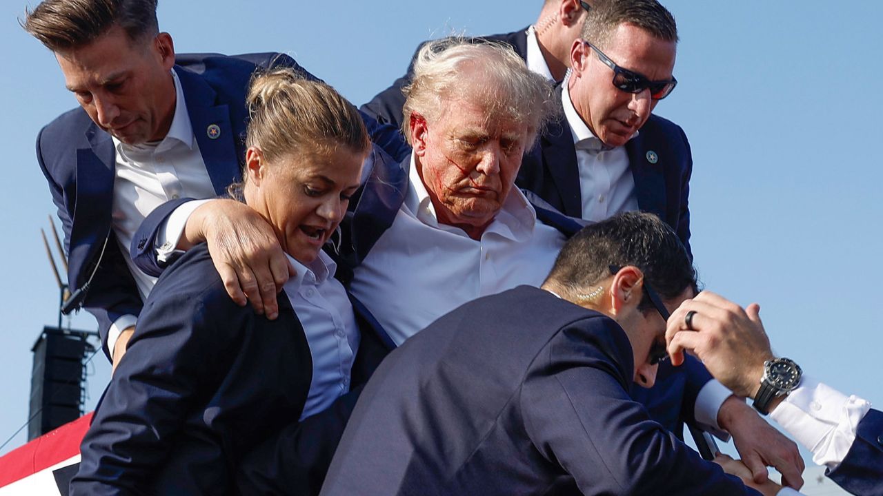 BUTLER, PENNSYLVANIA - JULY 13: Republican presidential candidate former President Donald Trump is rushed offstage by U.S. Secret Service agents after being grazed by a bullet during a rally on July 13, 2024 in Butler, Pennsylvania. Butler County district attorney Richard Goldinger said the shooter is dead after injuring former U.S. President Donald Trump, killing one audience member and injuring another in the shooting. (Photo by Anna Moneymaker/Getty Images)