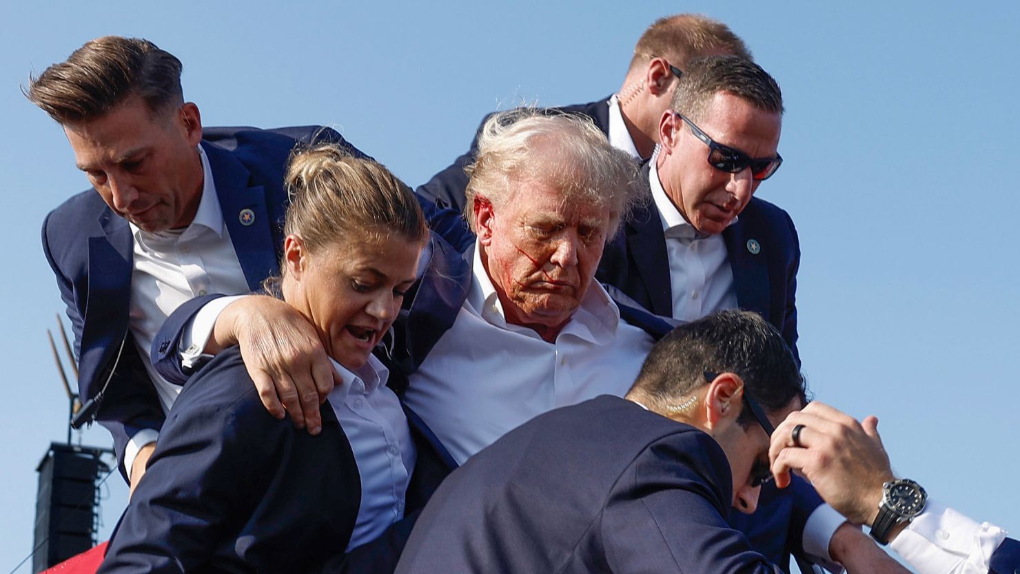 Republican presidential candidate former President Donald Trump is rushed offstage by US Secret Service agents after being grazed by a bullet during a rally on July 13, 2024, in Butler, Pennsylvania.