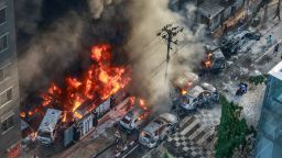 Smoke rises from the burning vehicles after protesters set them on fire near the Disaster Management Directorate office, during the ongoing anti-quota protest in Dhaka on July 18, 2024.