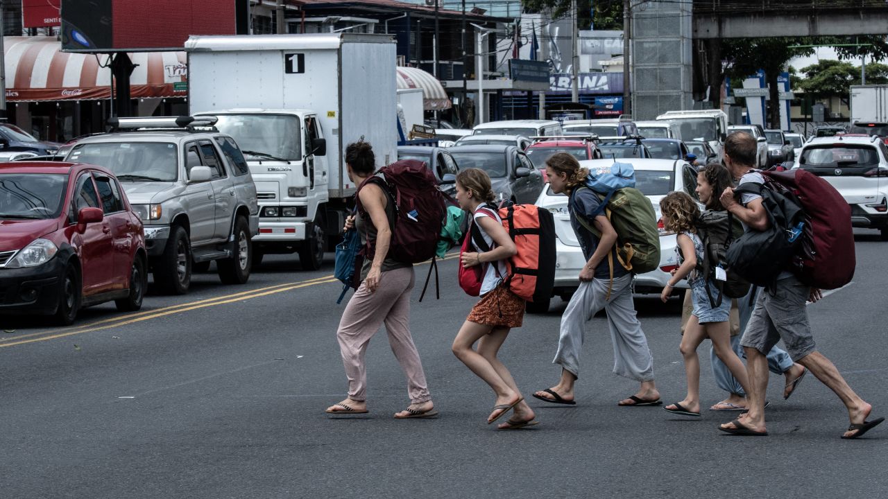 A tourist family crosses a street in San Jose, on July 18, 2024. The number of tourists visiting Costa Rica increased 14.5% in the first half of this year, compared to the same period in 2023, the Costa Rican Tourism Institute (ICT) reported on July 19, 2024. 'From January to June this year 1,532,443 tourists visited Costa Rica by air, representing an increase of 14.5% compared to the same period in 2023,' the ICT said in a half-yearly report. (Photo by Ezequiel BECERRA / AFP) (Photo by EZEQUIEL BECERRA/AFP via Getty Images)