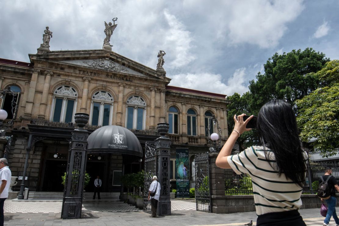 Una turista toma una foto frente al Teatro Nacional en San José, el 18 de julio de 2024.