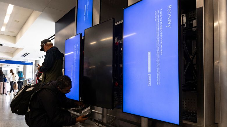 A Delta technician works on a set of screens displaying a blue page and reading "Recovery" in Terminal 2, Delta Airlines, at Los Angeles airport, on July 19, 2024. Airlines, banks, TV channels and other businesses were disrupted worldwide on Friday following a major computer systems outage linked to an update on an antivirus program.