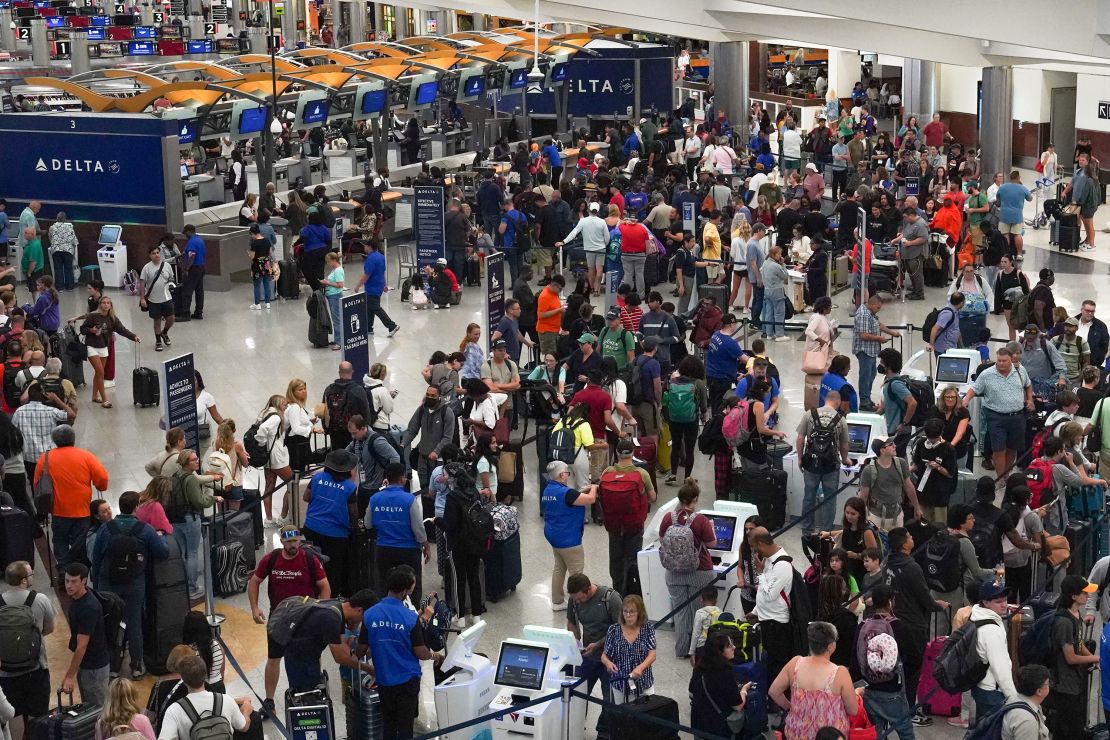 People wait in line at Hartsfield-Jackson International Airport on July 20, 2024 in Atlanta, Georgia. Following Friday's global IT outage, people were still having trouble navigating air travel, finding their luggage, and rebooking flights that had been canceled.