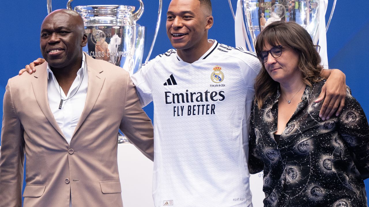 MADRID, SPAIN - JULY 16: Real Madrid new signing, Kylian Mbappe poses with his father Wilfried Mbappe and his mother Fayza Lamari  is unveiled at Estadio Santiago Bernabeu on July 16, 2024 in Madrid, Spain. (Photo by David Ramos/Getty Images)