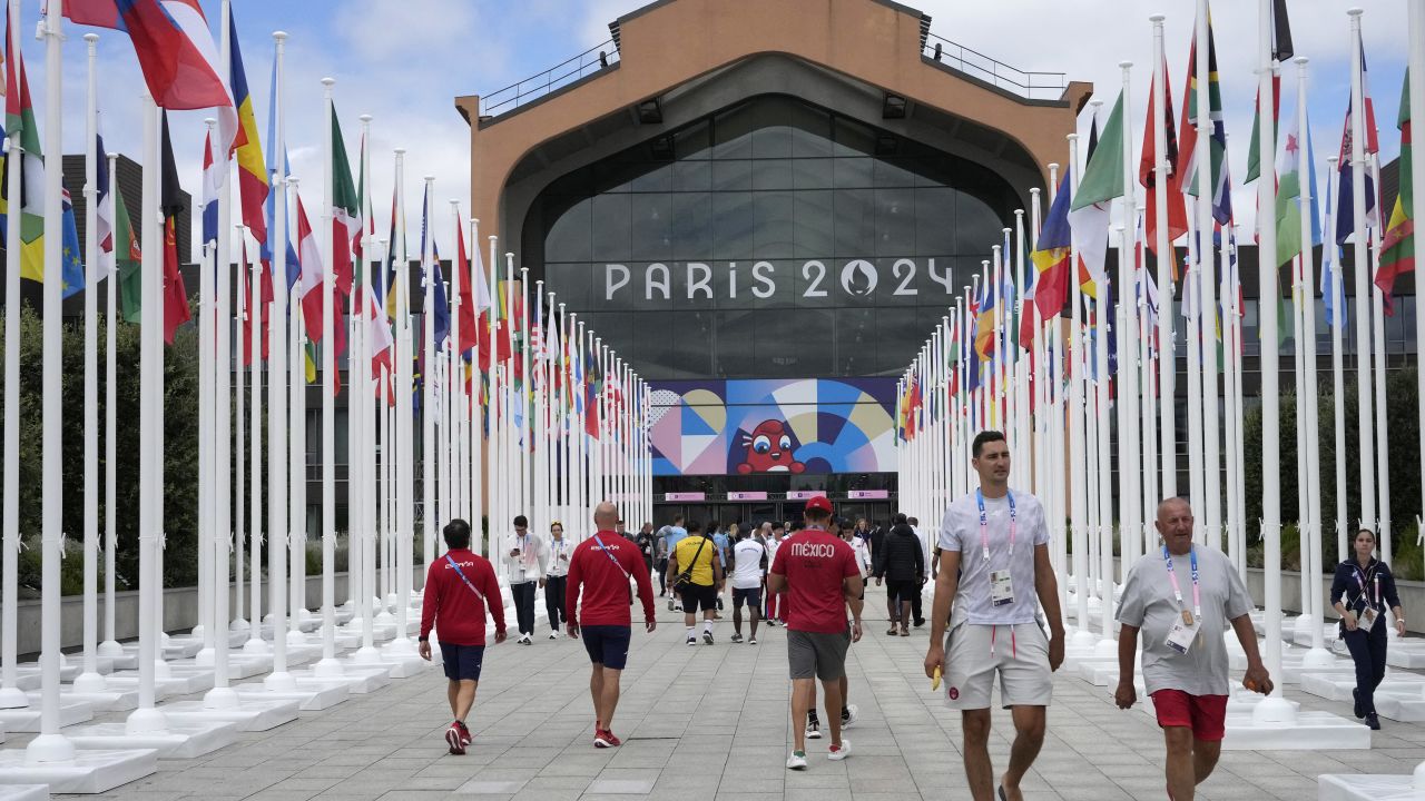 Participants of the Paris 2024 Olympics and Paralympics game walk in front of the cafeteria of the Olympic Village, in Saint-Denis, northern Paris, on July 22, 2024, ahead of the opening ceremony of Paris 2024 Olympic and Paralympic Games. (Photo by Michel Euler / POOL / AFP) (Photo by MICHEL EULER/POOL/AFP via Getty Images)