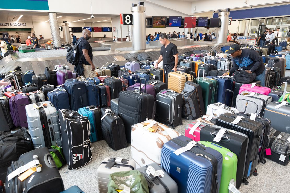 Delta passengers try to find their bags after canceled and delayed flights at Hartsfield-Jackson Atlanta International Airport on Monday.