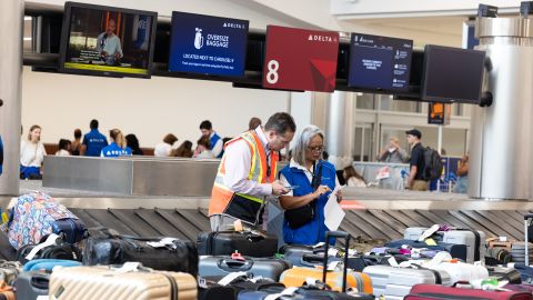 Delta Air Lines employees try to locate passengers' luggage after cancelled and delayed flights at Hartsfield-Jackson Atlanta International Airport on Monday.