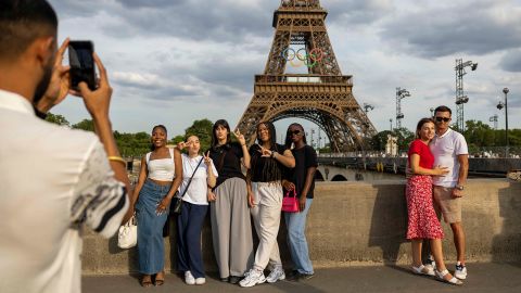 Tourists pose for a photo near Eiffel tower on July 17, 2024 in Paris, France.