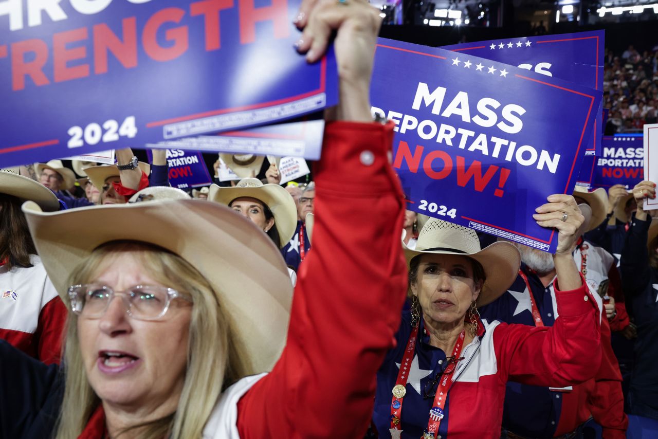 People hold signs reading "Mass Deportation Now!" during the Republican National Convention in Milwaukee on July 17.