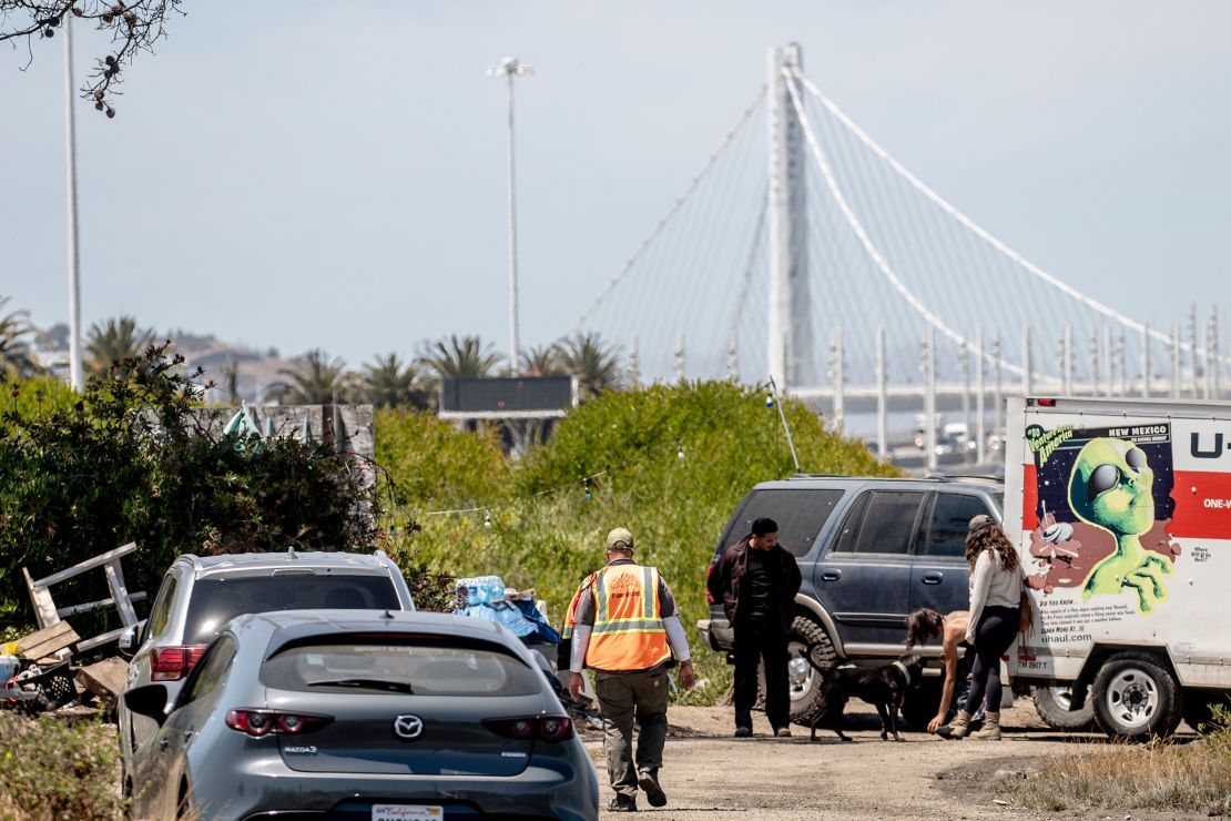 A city worker walks towards a homeless encampment near the San Francisco-Oakland Bay Bridge toll plaza ahead of a scheduled sweep on July 23.