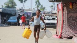 A boy carries containers as he heads to collect water in an area sheltering displaced Palestinians, in Khan Yunis in the southern Gaza Strip on July 24, 2024, amid the ongoing conflict between Israel and the Palestinian militant group Hamas. (Photo by Bashar TALEB / AFP) (Photo by BASHAR TALEB/AFP via Getty Images)