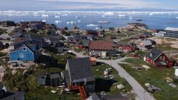 ILULISSAT, GREENLAND - JULY 15: Houses stand as icebergs drift by in Disko Bay on July 15, 2024 in Ilulissat, Greenland. Greenlandic authorities are seeking to improve the territory's infrastructure for tourism. Ilulissat is among the main tourist destinations in Greenland.  (Photo by Sean Gallup/Getty Images)