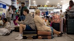 CRAWLEY, ENGLAND - JULY 19: Passengers queue at Gatwick Airport amid a global IT outage on July 19, 2024 in Crawley, United Kingdom. Businesses, travel companies and Microsoft users across the globe were among those affected by a tech outage today. (Photo by Jack Taylor/Getty Images)