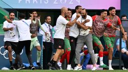 Morocco's coach Tarik Sektioui (3R), Morocco's substitute players and staff celebrate at the end of the match which had started again in an emptied stadium following incidents, a two-hour interruption and the cancellation of Argentina's equalizing goal, in the men's group B football match between Argentina and Morocco during the Paris 2024 Olympic Games at the Geoffroy-Guichard Stadium in Saint-Etienne on July 24, 2024.