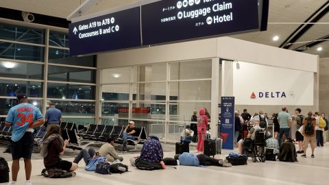 Travelers wait in a long line to speak with a Delta representative at the help desk in the McNamara terminal at the Detroit Metropolitan Wayne County Airport on July 20 in Detroit, Michigan.