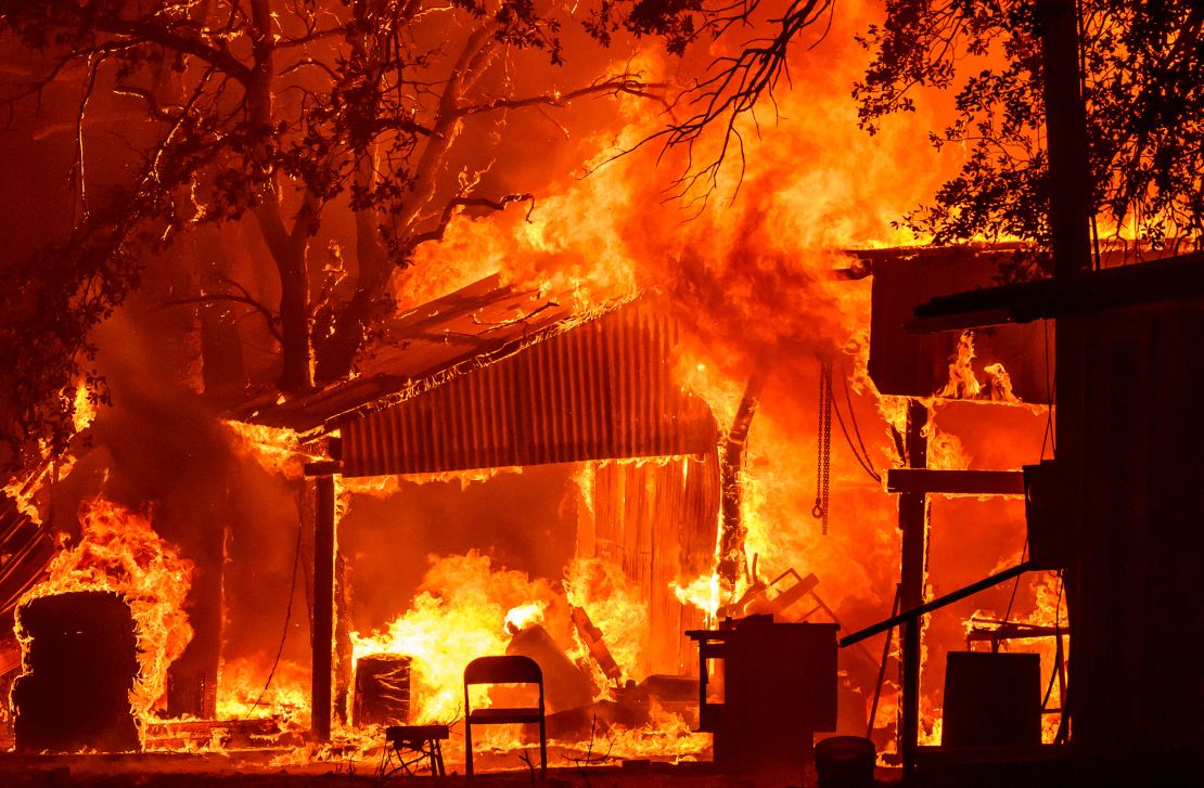 TOPSHOT - A property is seen in flames as the Park fire continues to burn near Paynes Creek in unincorporated Tehama County, California on July 26, 2024. A huge, fast-moving and rapidly growing wildfire in northern California has forced more than 4,000 people to evacuate as firefighters battle gusty winds and perilously dry conditions, authorities said on July 26. (Photo by JOSH EDELSON / AFP) (Photo by JOSH EDELSON/AFP via Getty Images)