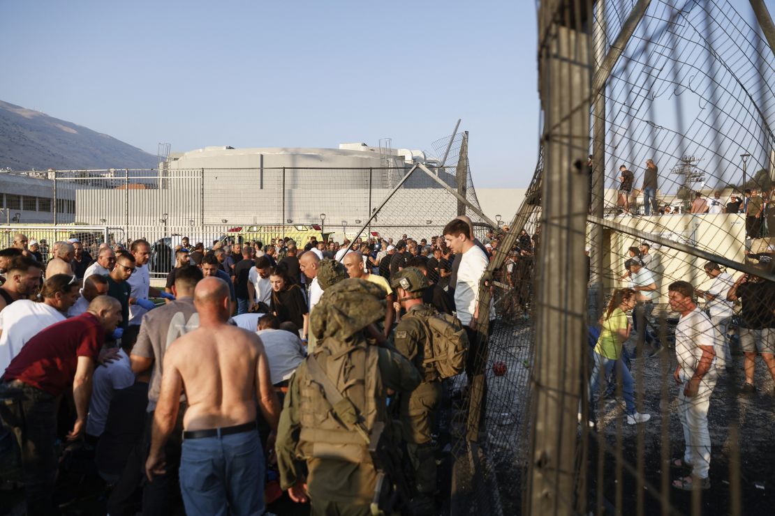 Israeli security forces and local residents gather at a site of the rocket attack in the Golan Heights area on July 27, 2024.