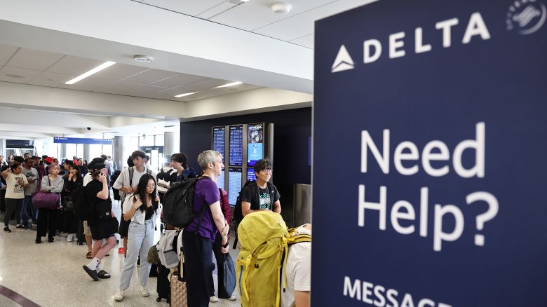 Travelers wait in line on the check-in floor of the Delta Air Lines terminal at Los Angeles International Airport on Wednesday.