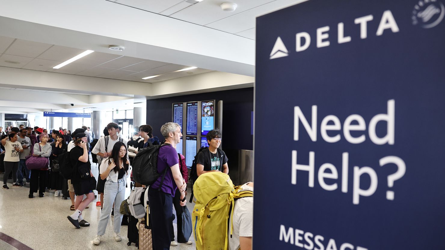 Travelers wait in line on the check-in floor of the Delta Air Lines terminal at Los Angeles International Airport on Wednesday.