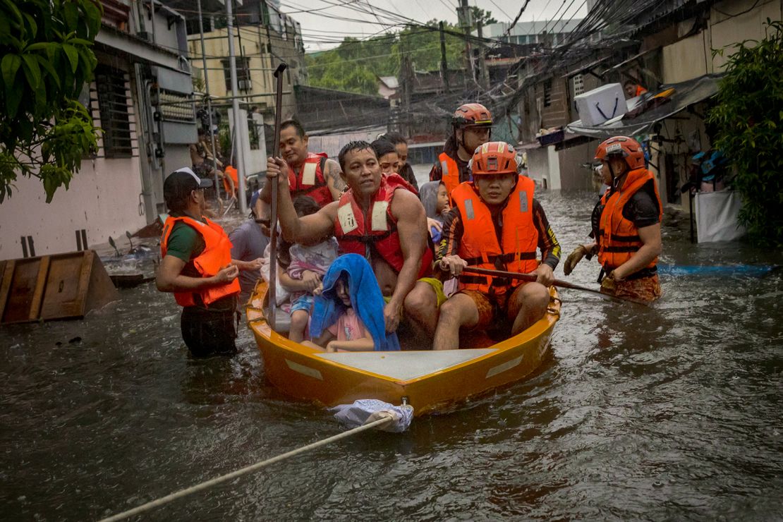 Rescuers evacuate residents from their flooded homes on July 24, 2024 in Quezon city, Metro Manila, Philippines.