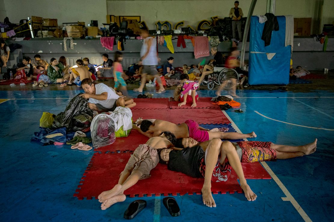 Residents whose homes were flooded by Typhoon Gaemi and monsoon rains occupy a basketball court converted into an evacuation center on July 24, 2024 in Quezon city, Metro Manila, Philippines.