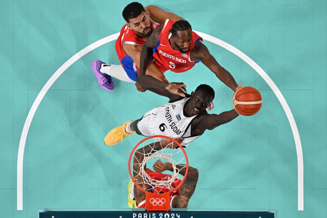 Maluach goes to the basket for South Sudan past Puerto Rico's Davon Reed in the men's preliminary round group C basketball match during the Paris 2024 Olympic Games.