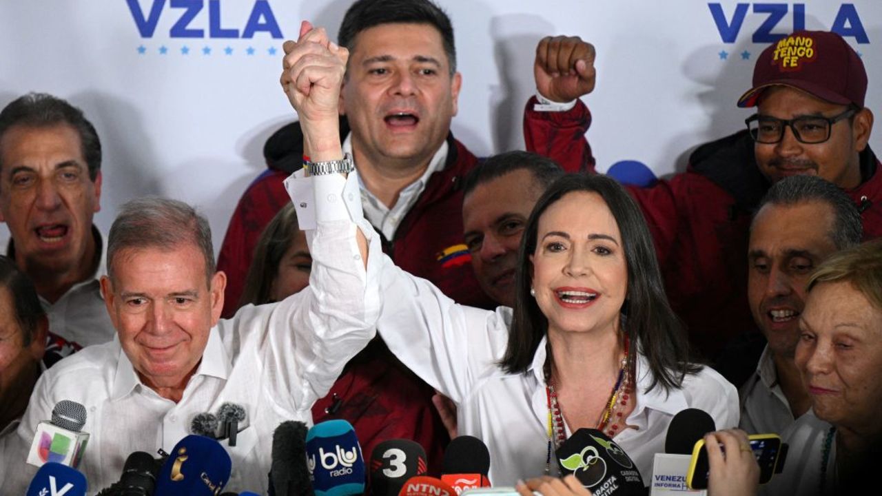 Venezuelan opposition leader Maria Corina Machado (R) speaks with the media next to opposition presidential candidate Edmundo Gonzalez Urrutia while waiting for the results of the presidential election, in Caracas on July 28, 2024. Venezuela's opposition leader Maria Corina Machado urged voters in the country's presidential election to remain at their polling stations to verify the counting process in the