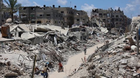 Palestinians cycle past destroyed buildings leveled in a previous Israeli military bombardment of Beit Lahia, in the northern Gaza Strip on Monday.