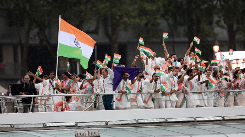 Sharath Kamal Achanta and V. Sindhu Pusarla, flagbearers of Team India, wave their flag on the River Seine during the opening ceremony of the Olympic Games in Paris on July 26, 2024.