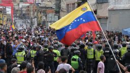Un hombre ondea una bandera venezolana mientras los manifestantes chocan con agentes de policía durante una protesta contra el gobierno del presidente Nicolás Maduro en Caracas el 29 de julio de 2024, un día después de las elecciones presidenciales venezolanas. (Foto: Yuri CORTEZ / AFP) (Photo by YURI CORTEZ/AFP via Getty Images).