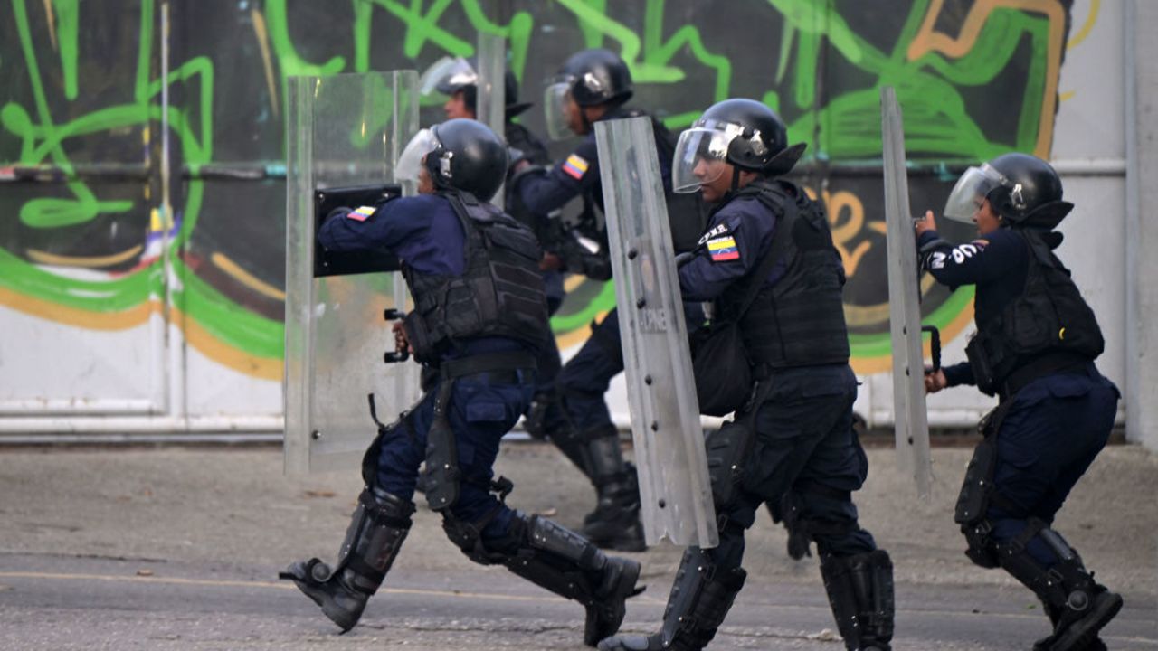 Police officers run towards demonstrators during a protest against Venezuelan President Nicolas Maduro in Caracas on July 29, 2024, a day after the Venezuelan presidential election. Protests erupted in parts of Caracas Monday against the re-election victory claimed by Venezuelan President Nicolas Maduro but disputed by the opposition and questioned internationally, AFP journalists observed. (Photo by Yuri CORTEZ / AFP) (Photo by YURI CORTEZ/AFP via Getty Images)