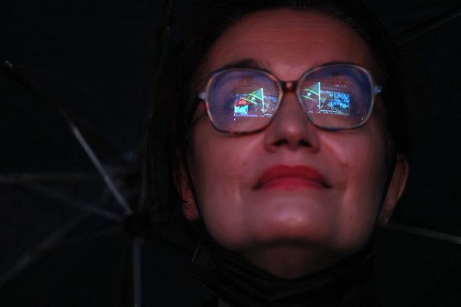 The flag of St. Kitts and Nevis is reflected in the glasses of a spectator.