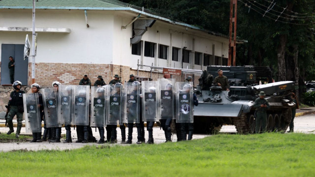 Police officers wait inside the 41st Armored Brigade, known as Paramacay Fort, as demonstrators gather at the entrance during a protest against Venezuelan President Nicolas Maduro's government in Valencia, state of Carabobo, Venezuela, on July 29, 2024, a day after the Venezuelan presidential election. Protests erupted in parts of Caracas Monday against the re-election victory claimed by Venezuelan President Nicolas Maduro but disputed by the opposition and questioned internationally, AFP journalists observed. (Photo by Juan Carlos HERNANDEZ / AFP) (Photo by JUAN CARLOS HERNANDEZ/AFP via Getty Images)