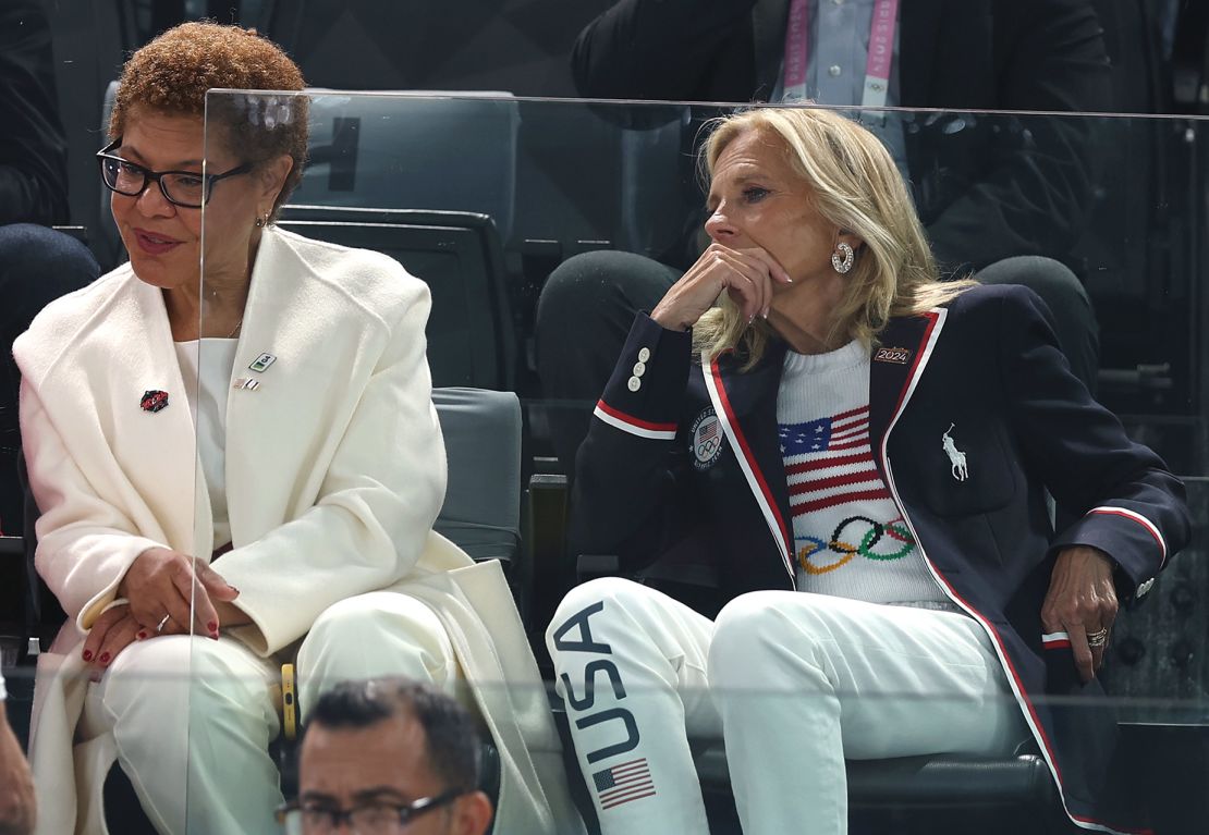 US First Lady Dr. Jill Biden seen at the artistic gymnastics men's qualification event in a Ralph Lauren Team USA knit, and a matching tracksuit. Next to her Los Angeles mayor, Karen Bass, is wearing all white.