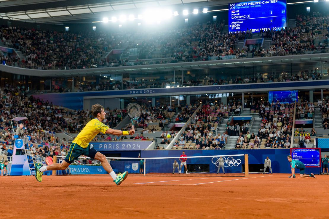 Ebden reaches for a forehand against Djokovic.